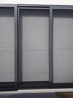 CB: 56 Stacker Sliding Security Doors Fitted With Stainless Steel Mesh. Displaying The Two Security Doors In A Closed Position & The Third Security Fixed Panel Fitted With Tamper Proof Screws In Monument.